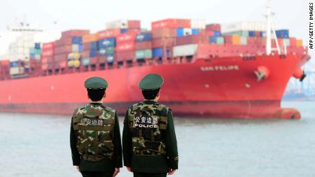 Police officers watching a cargo ship at a port in Qingdao in 2018. China's official growth rate for last year is expected to be around 6.5%, the weakest in nearly three decades.