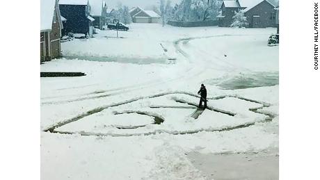 Ryan Hill of Lee's Summit, Missouri, shovels the Kansas City Chiefs' logo out of snow on his driveway. Despite the snow, an NFL playoff game between the Chiefs and the Indianapolis Colts will be played Saturday at Arrowhead Statdium in Kansas City. 