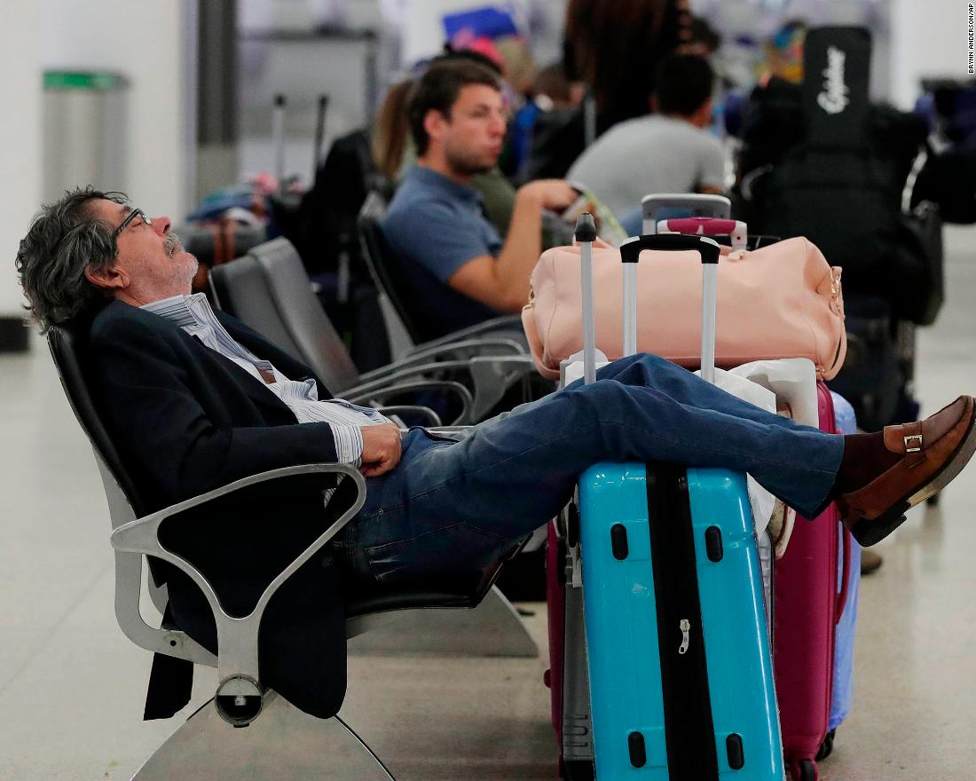 A traveler sleeps near a closed terminal at Miami International Airport on January 12.