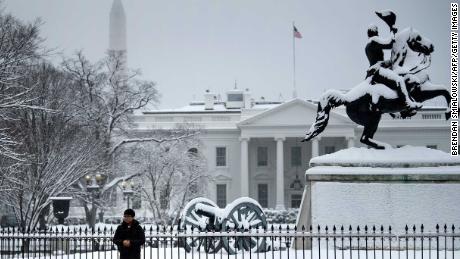 A tourist poses for a photo in Lafayette Square near the White House during a winter storm on the 23rd day of the US government shutdown January 13, 2019 in Washington, DC. - Washington area residents woke up to a winter wonderland, and may need to shovel aside several inches of snow that fell overnight as a winter storm warning remains in effect until 6 p.m. Sunday and more snow is expected to fall. (Photo by Brendan Smialowski / AFP)        (Photo credit should read BRENDAN SMIALOWSKI/AFP/Getty Images)
