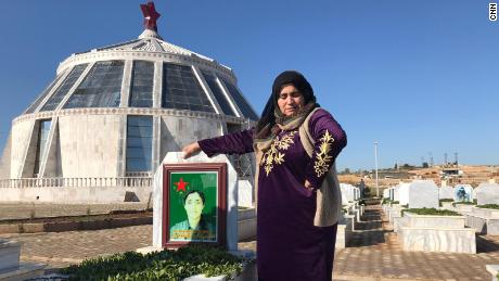 The mother of Peyman Tolhildan, 19, grieves by her grave in Kobani, northern Syria