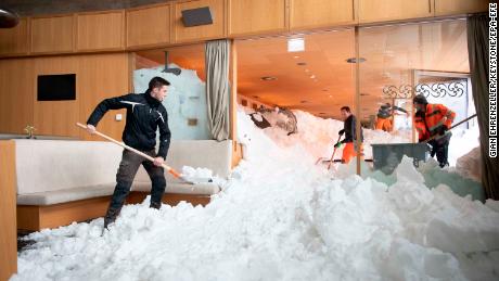 Emergency service workers clear snow from the inside a hotel on the Schwaegalp, Switzerland, after an avalanche.