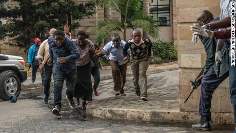 People run for cover after being rescued from the Dusit hotel.