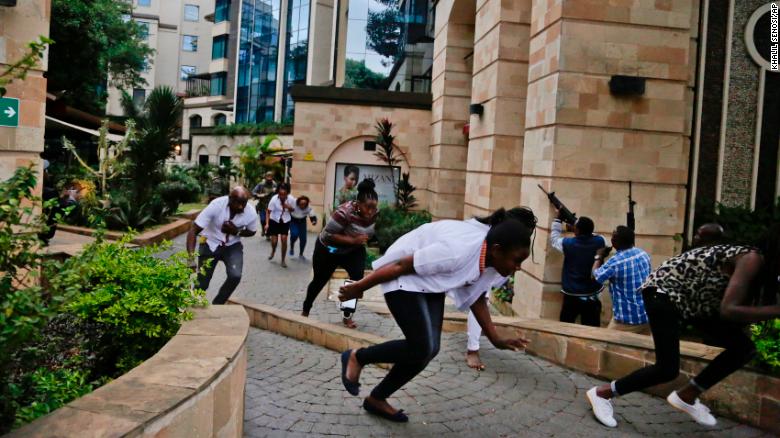 Civilians flee as security forces work to clear the buildings of a hotel complex in Nairobi during the deadly attack. 