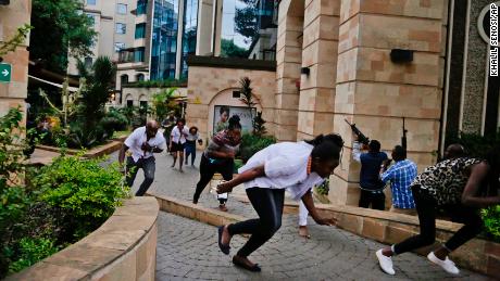 Civilians flee as security forces work to clear the buildings of a hotel complex in Nairobi, Kenya during the deadly attack. 