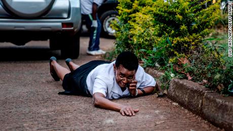 A woman hides behind a car during last week's terror attack at a hotel complex in Nairobi. 