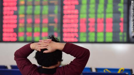 An investor watching the electronic board at a stock exchange hall in Fuyang, China. On Wednesday morning, the Shanghai Composite was trading largely flat. 