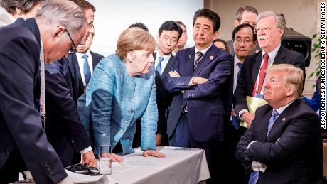 German Chancellor Angela Merkel deliberates with US President Donald Trump on the sidelines of the G7 summit on June 9, 2018 in Charlevoix, Canada.