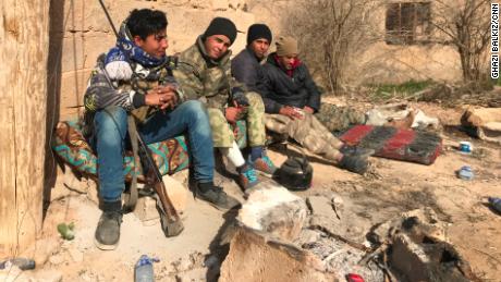 Syrian Democratic Forces (SDF) troops take a break between the town of Sha'fa and Soussa, one of the last ISIS-controlled villages in southeast Syria. 