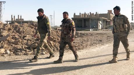 Three SDF soldiers in the southeast Syrian town of Hajin after it was liberated from ISIS.