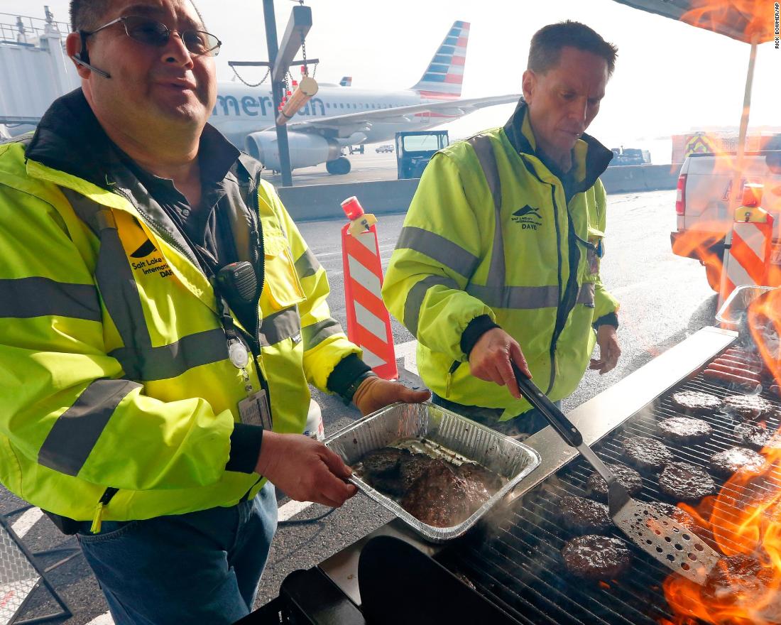 Airport operation workers flip burgers and hot dogs at Salt Lake City International Airport on January 16. They treated federal workers to a free lunch.
