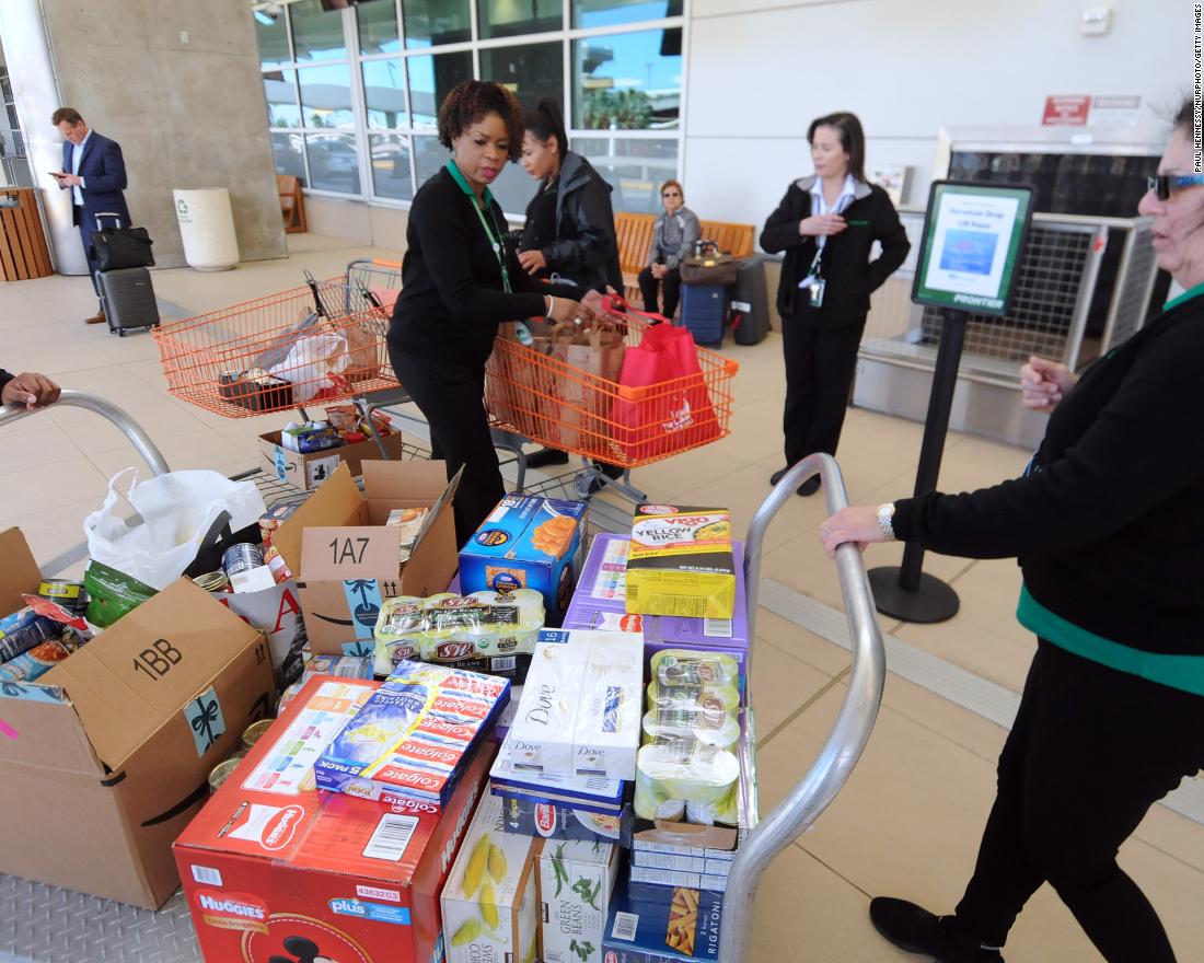 Employees of Frontier Airlines bring donated food for federal workers to Orlando International Airport on Wednesday, January 16.