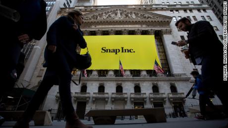 Pedestrians pass in front of Snap Inc. signage displayed on the exterior of the New York Stock Exchange during the company's initial public offering in 2017.