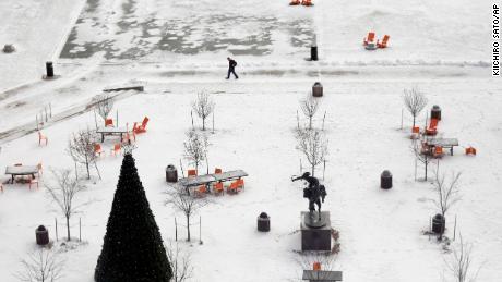 A man walks through snow-covered Barney Allis Plaza in Kansas City, Missouri. 