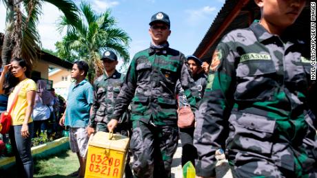 A policeman carries a ballot box at a voting precinct in Cotabato on the southern Philippine island of Mindanao on January 21, 2019, during a vote on giving the nation's Muslim minority greater control over the region.