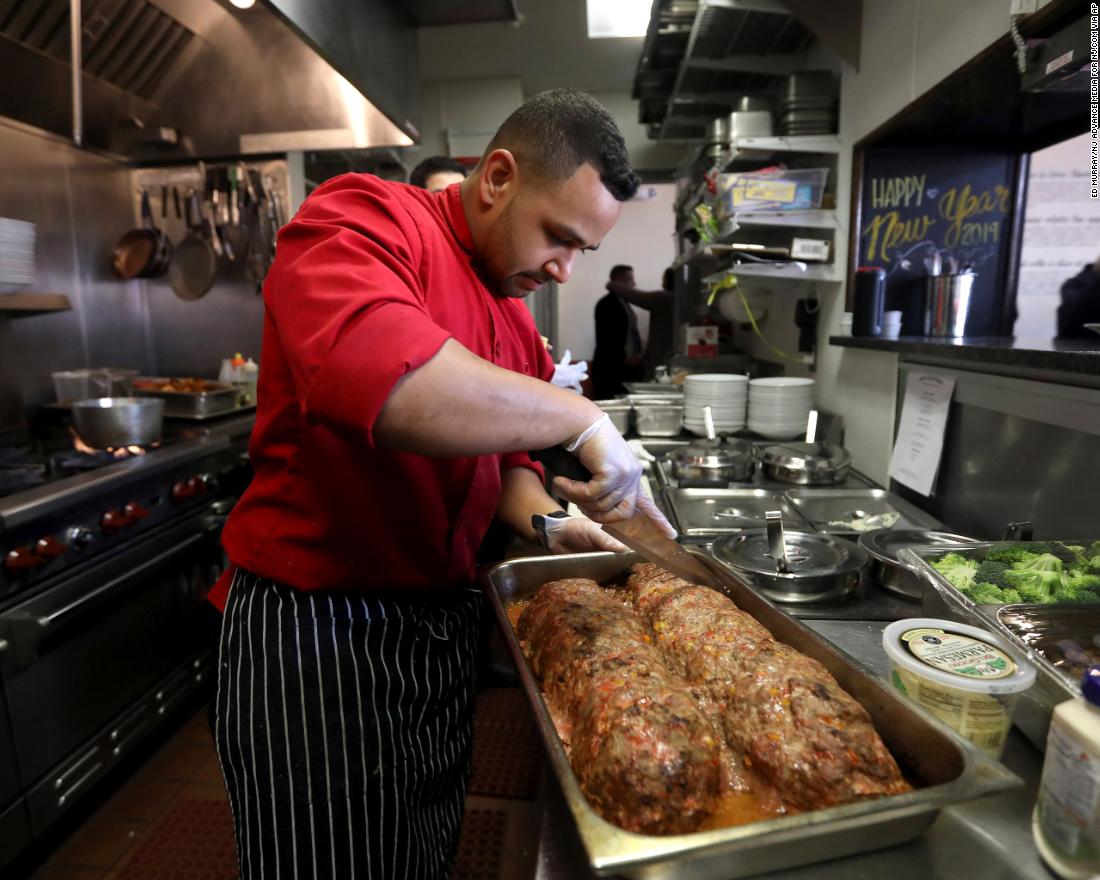Chef Joshua Wiggins cuts portions of meatloaf for furloughed federal workers in Red Bank, New Jersey, on Monday, January 21. The free lunch was served at JBJ Soul Kitchen, the restaurant of rock star Jon Bon Jovi.