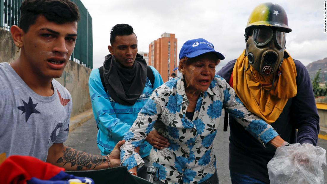 Opposition supporters react to tear gas as they take part in the Caracas rally on January 23. Sporadic clashes erupted, but Maduro&#39;s military response to the protests seemed more measured than in the past.