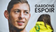 An FC Nantes supporter stands beside a portrait of Argentinian striker Emiliano Sala prior to a team training session at the training centre La Joneliere in La Chapelle-sur-Erdre, western France, on January 24, 2019, three days after the plane carrying Sala vanished over the English Channel. - Police on January 24 ended their search for new Premier League player Emiliano Sala, saying the chances of finding the Argentine alive three days after his plane went missing over the Channel were "extremely remote". Sala, 28, was on his way from Nantes in western France to the Welsh capital to train with his new teammates for the first time after completing a £15 million ($19 million) move to Cardiff City from French side Nantes on January 19. (Photo by LOIC VENANCE / AFP)        (Photo credit should read LOIC VENANCE/AFP/Getty Images)