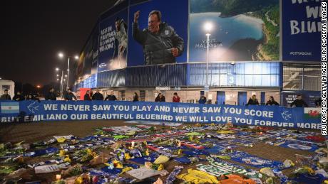 Cardiff City fans unveil a flag in front of tributes for their forward Emiliano Sala after the search for the missing footballer and pilot was called off.