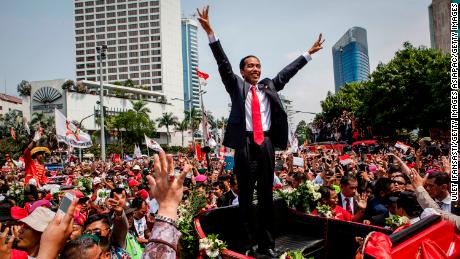 Jokowi waves to the crowd while on his journey to Presidential Palace following his election in October 2014.