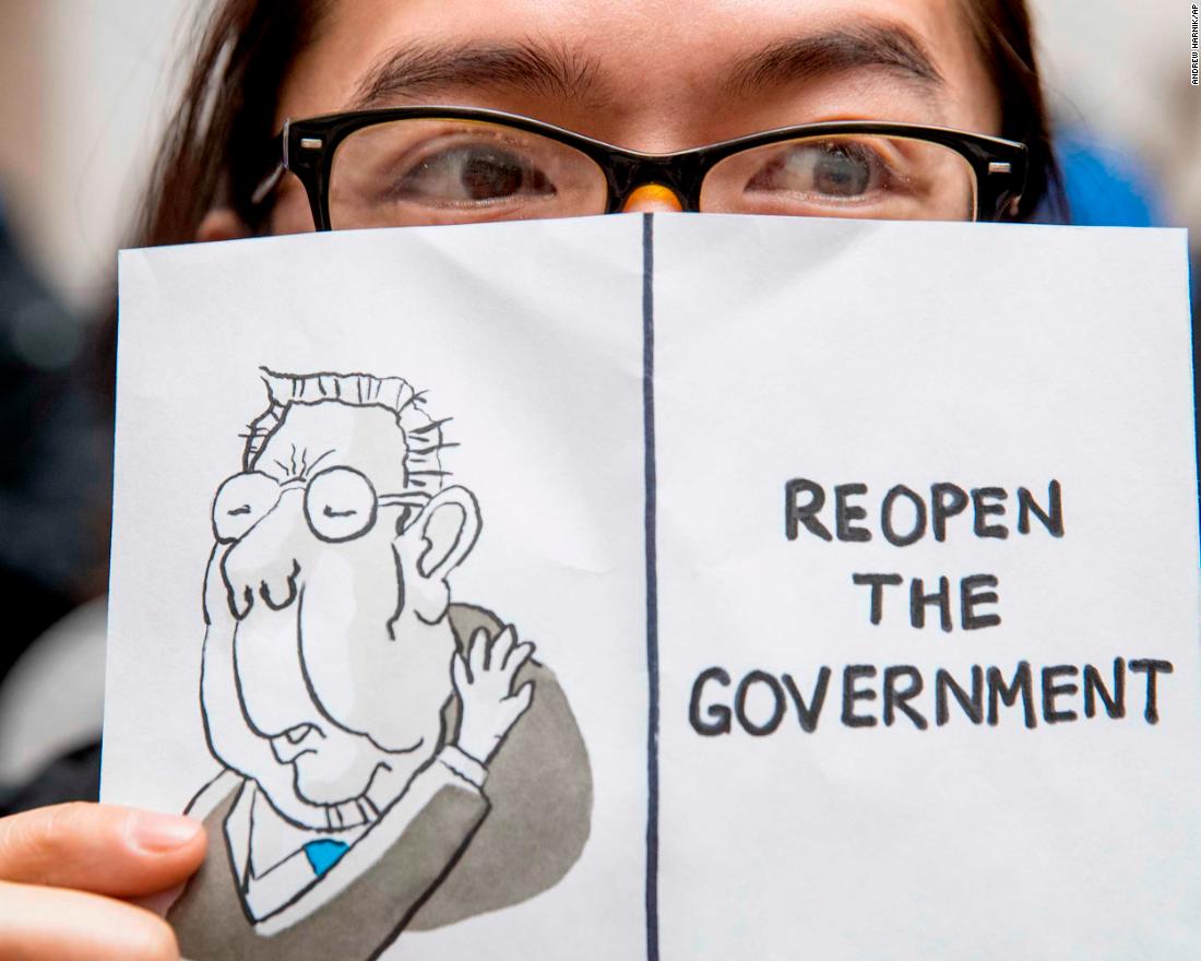 A furloughed worker displays a sign that reads &quot;Reopen the Government&quot; during a protest in Washington on January 23.