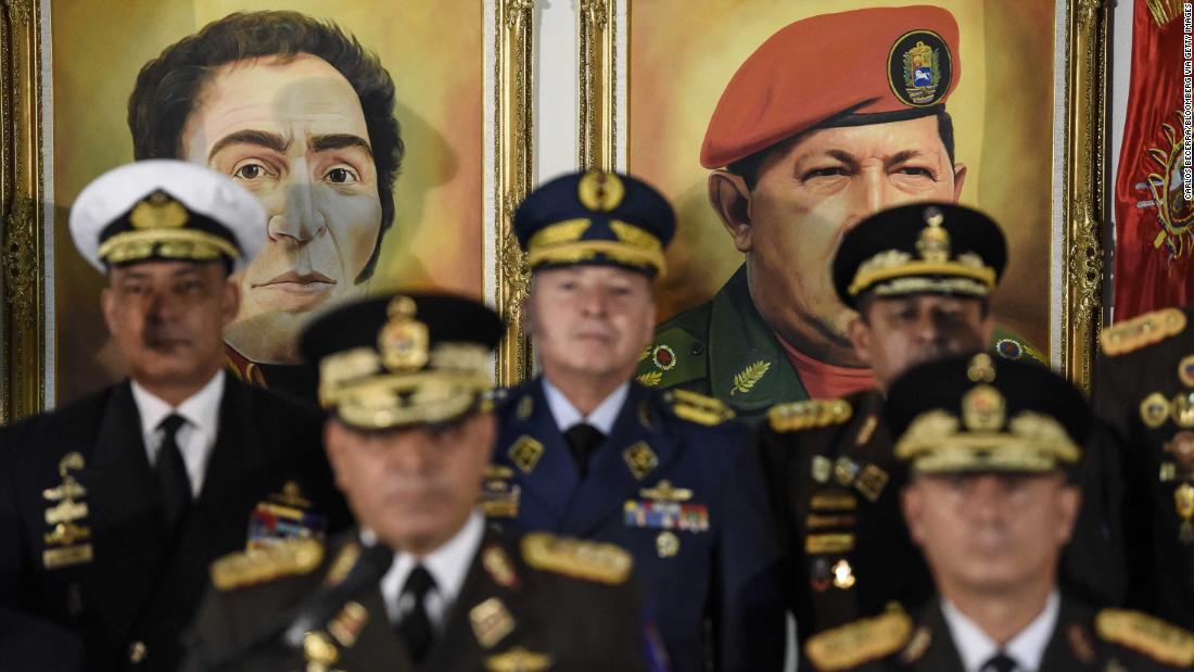 Portraits of former Venezuelan leaders Simon Bolivar and Hugo Chavez hover in the background as Venezuelan Defense Minister Vladimir Padrino Lopez, bottom left, addresses a news conference in Caracas on Thursday, January 24. Venezuela&#39;s top military officials swore their allegiance to Maduro after other nations recognized Guaido as head of state.