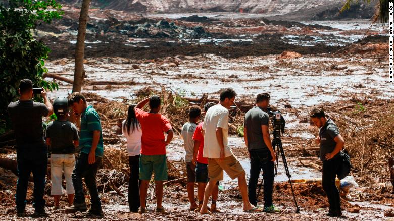 People observe the mud masses Friday after the break of the dam at the Feijao mine. 