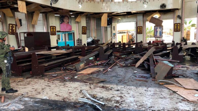 In this photo provided by WESMINCOM Armed Forces of the Philippines, a soldier views the site inside a Roman Catholic cathedral in Jolo, the capital of Sulu province in the southern Philippines after two bombs exploded Sunday, Jan. 27, 2019. The Philippine government says it will "pursue to the ends of the earth the ruthless perpetrators" behind bomb attacks that killed over a dozen people and wounded many more during a Sunday Mass at a cathedral on the restive southern island. (WESMINCOM Armed Forces of the Philippines Via AP)