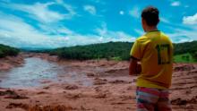 TOPSHOT - A boy looks at an area in the community of Casa Grande affected by a sludge after the collapse, two days ago, of a dam at an iron-ore mine belonging to Brazil's giant mining company Vale near the town of Brumadinho, state of Minas Gerias, southeastern Brazil, on January 27, 2019. - Communities were devastated by a dam collapse that killed at least 37 people at a Brazilian mining complex -- with hopes fading for 250 still missing. A barrier at the site burst on Friday, spewing millions of tons of treacherous sludge and engulfing buildings, vehicles and roads. (Photo by Mauro PIMENTEL / AFP)        (Photo credit should read MAURO PIMENTEL/AFP/Getty Images)
