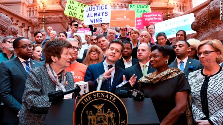 New York Sen. Brad Hoylman, center, flanked by former Assemblywoman Margaret Markey, left, and Senate Majority Leader Andrea Stewart-Cousins, right, join survivors and advocates speaking in favor of the legislation.