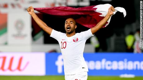 Qatar&#39;s midfielder Ali Yahya celebrates the win with the national flag during the 2019 AFC Asian Cup quarter-final football match between South Korea and Qatar at Zayed Sports City in Abu Dhabi on January 25, 2019. (Photo by Roslan RAHMAN / AFP)        (Photo credit should read ROSLAN RAHMAN/AFP/Getty Images)
