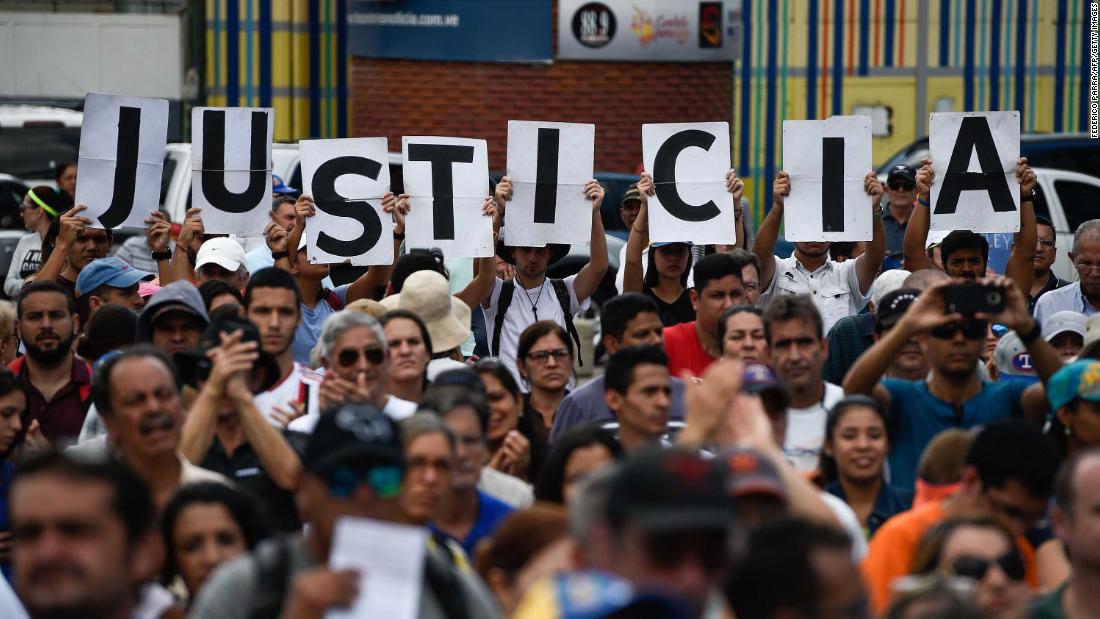 Supporters of Venezuela&#39;s opposition hold up letters that read &quot;Justice&quot; at a rally to hear Guaido speak in Caracas on Saturday, January 26.
