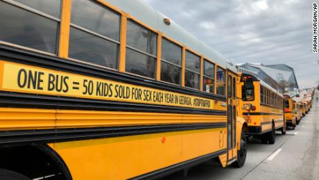 A line of school buses with new decals to draw attention to human trafficking make their way on a road in Atlanta on January 2. 