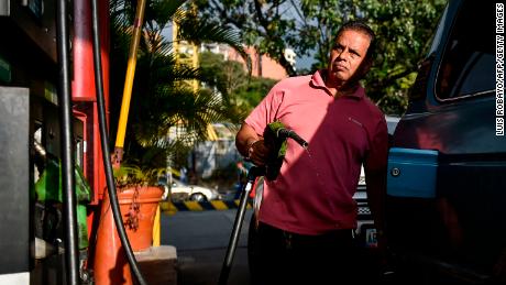 A man pumps fuel at a gas station in Caracas, on January 29, 2019. - The United States announced sanctions against Venezuela&#39;s state oil company Monday in a coordinated effort with the main opposition leader to cripple embattled President Nicolas Maduro&#39;s power base. (Photo by Luis ROBAYO / AFP)        (Photo credit should read LUIS ROBAYO/AFP/Getty Images)