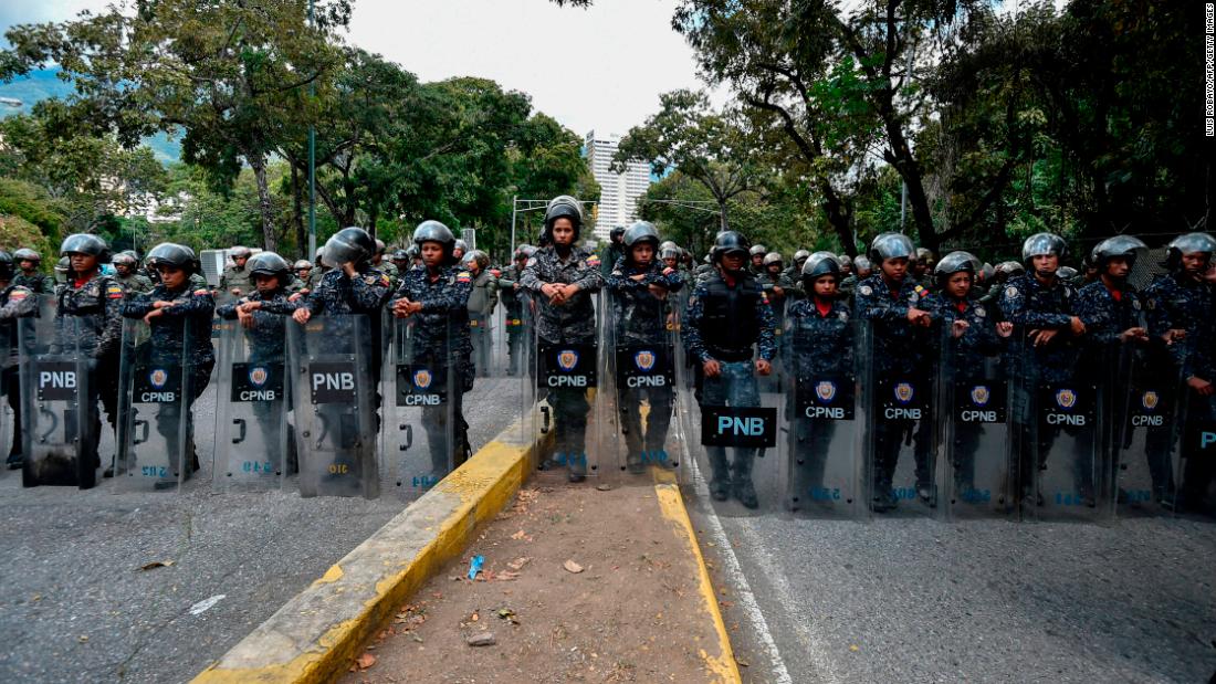 Members of the National Police line up to guard the entrance of Venezuela&#39;s Central University in Caracas during an anti-government protest on January 30.
