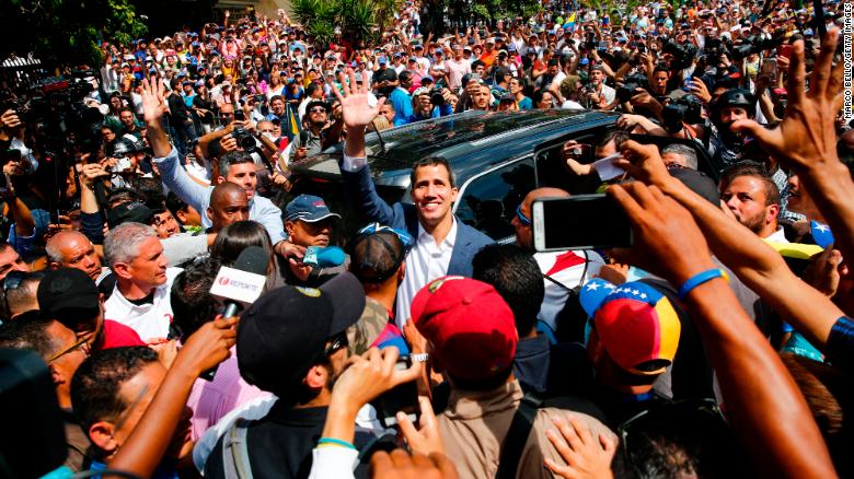 Juan Guaido waves to supporters as he leaves a Saturday rally in Caracas.