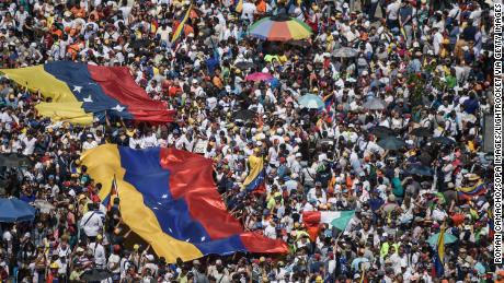 Guaido supporters hold huge Venezuelan flags during a protest against Maduro on Saturday. 