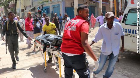 Emergency rescue staff carry the body of a victim on a gurney at the scene of a car-bomb attack on February 4, 2019 in Somalia capital Mogadishu&#39;s Hamarwayne District. (Photo by ABDIRAZAK HUSSEIN FARAH / AFP)        