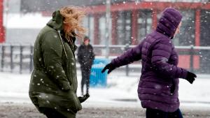 Pedestrians huddle against snow and a cold wind Monday morning, Feb. 4, 2019, in Seattle. Western Washington was hit by a major winter storm, with several inches of snow, cold temperatures and bone-chilling winds overnight and into the day Monday. Numerous school districts have closed for the day and temperatures were in the low 20s across much of the region with wind chills in the teens. (AP Photo/Elaine Thompson)