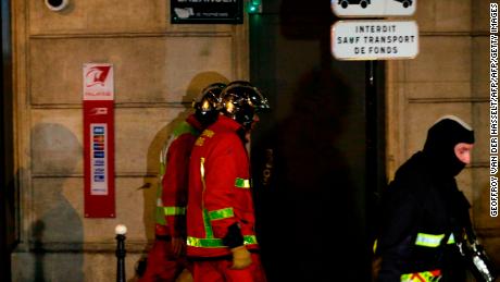 Firefighters walk along the rue Erlanger, near the scene of the deadly blaze. 