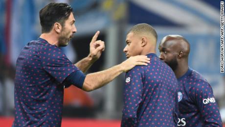 Gianluigi Buffon (L) gestures as he speaks with Paris Saint-Germain's French forward Kylian Mbappe (C) and Stanley Nsoki (R).