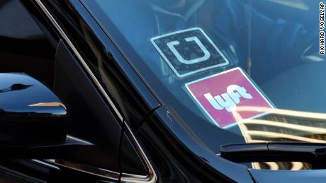 FILE - In this Jan. 12, 2016 file photo, a ride share car displays Lyft and Uber stickers on its front windshield in downtown Los Angeles, Calif.  Ride-hailing giants Uber and Lyft have launched subscription plans promising savings for trips to the gym, to work or around town. The ride-hailing companies stand to gain by increasing customer loyalty in a competitive market and securing more predictable revenue at a time when both companies are heading to an initial public offering.   (AP Photo/Richard Vogel, File)