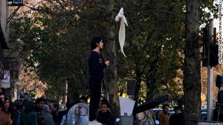 Vida Movahedi stands on a telecoms box on a Tehran street after removing her headscarf and holding a stick to protest against the country&#39;s compulsory hijab rules.