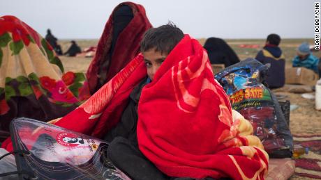 Boys huddle under blankets provided by the Syrian Democratic Forces.