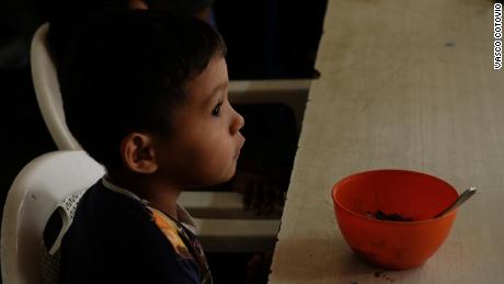 Imael, 5, with a bowl of rice and beans, his only meal of the day.