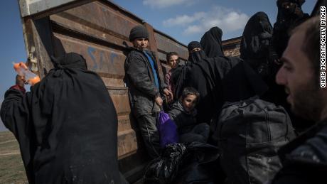 Civilians who fled fighting in Baghouz Al-Fawqani board trucks Saturday after being screened by the Syrian Democratic Forces.