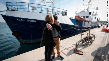 Abdullah Kurdi and his sister Tima stand in front of a rescue ship named after Alan Kurdi during the ship's inauguration in Palma de Mallorca on Sunday.