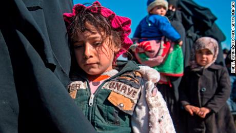 Women and children stand in a field after fleeing from the Baghouz area in the eastern Syrian province of Deir Ezzor on February 12.