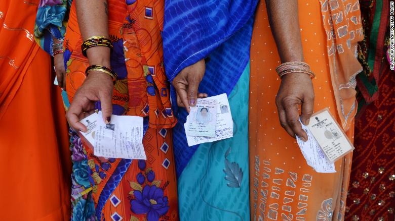 Indian voters stand outside of a polling booth during the last national election in 2014.