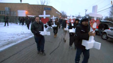 Mourners carry crosses in Aurora, Illonois, honoring the five people killed.